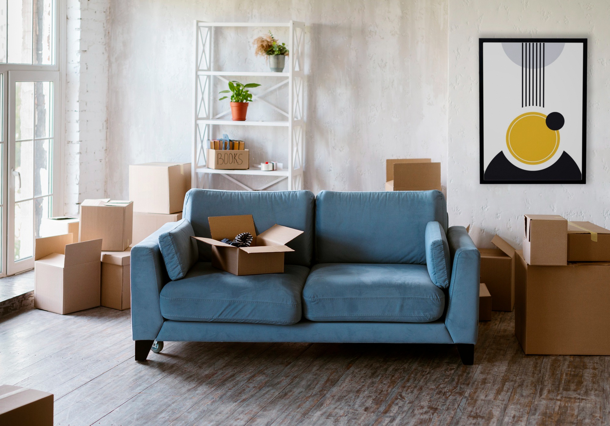 Blaues Sofa mit Karton darauf während eines Umzugs. Umzugsunternehmen in der Nähe Berlin Hering.